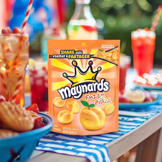 Maynards Fizzy Peach snack package on a table with drinks and snacks in the background
